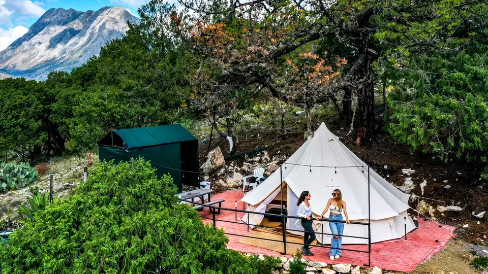 Carpa de glamping con vista a la sierra y dos huéspedes en Santiago